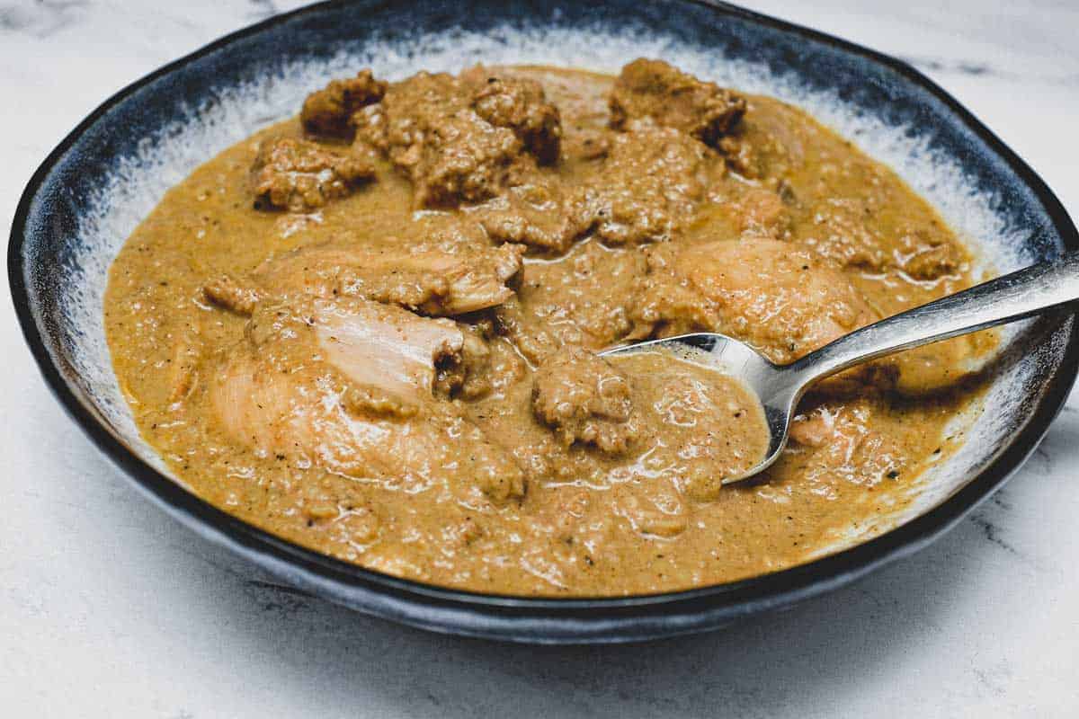 A bowl of Chicken Korma Curry with a spoon