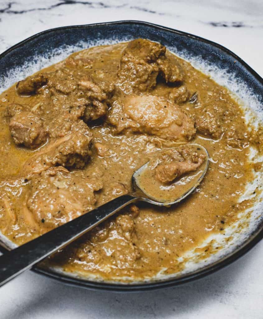 A bowl of Chicken Korma Curry with a spoon