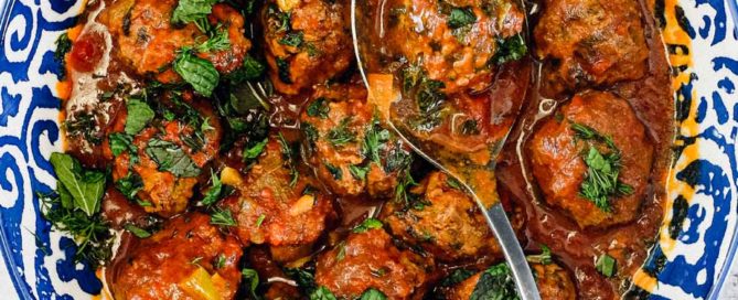A large bowl of Moroccan Kefta (meatballs) tagine with a spoon.