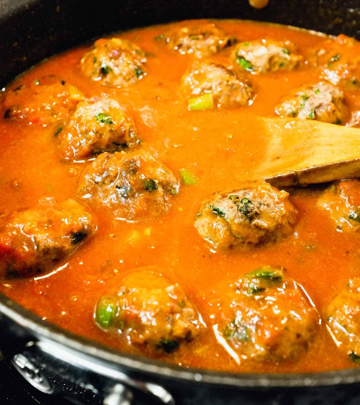 Moroccan Kefta (meatballs) simmering in a tomato sauce.