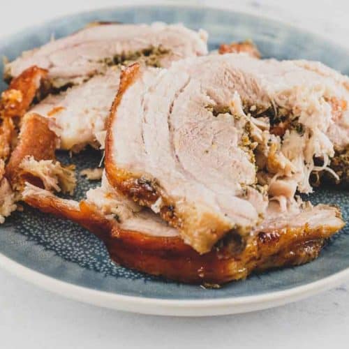 rolled pork belly porchetta sliced with golden crispy skin