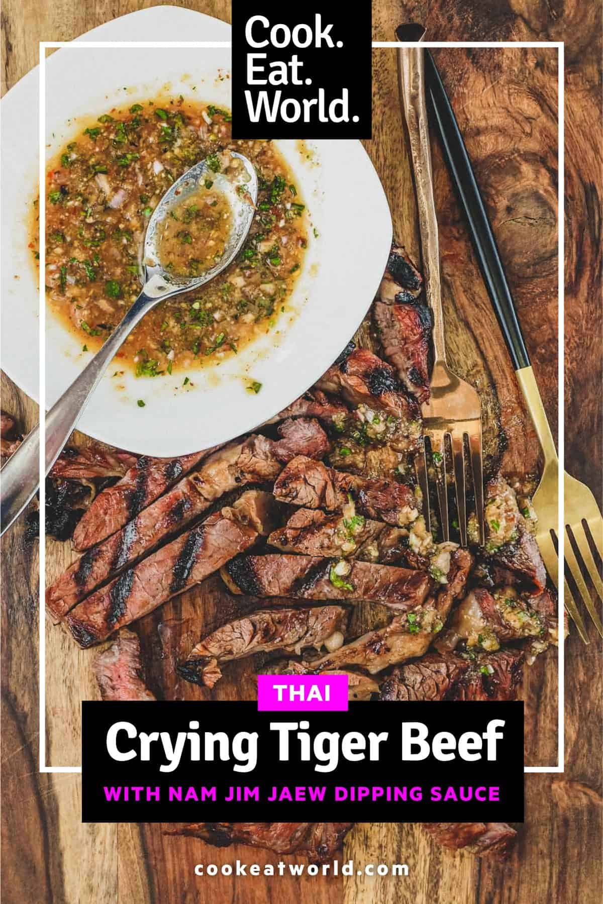 a wooden board with Thai Crying Tiger Beef with Nam Jim Jaew Sauce