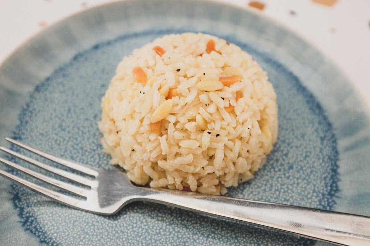 A mound of Turkish Pilav on a plate with a fork