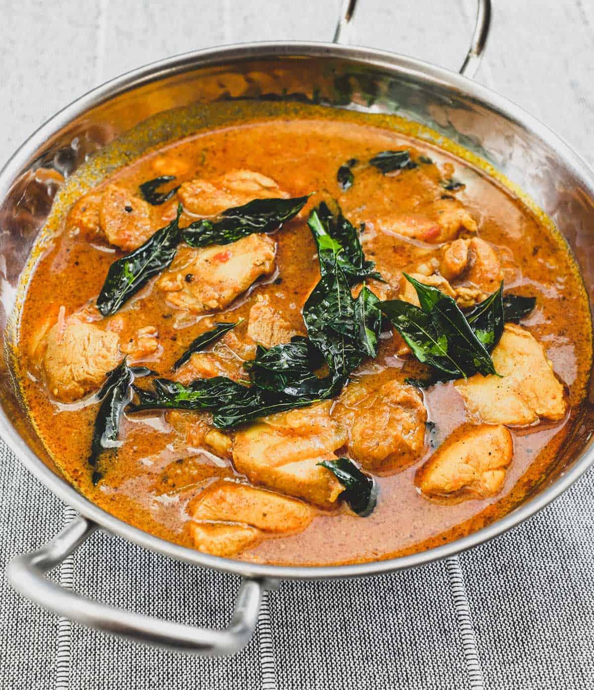 Achari Chicken in a silver serving bowl