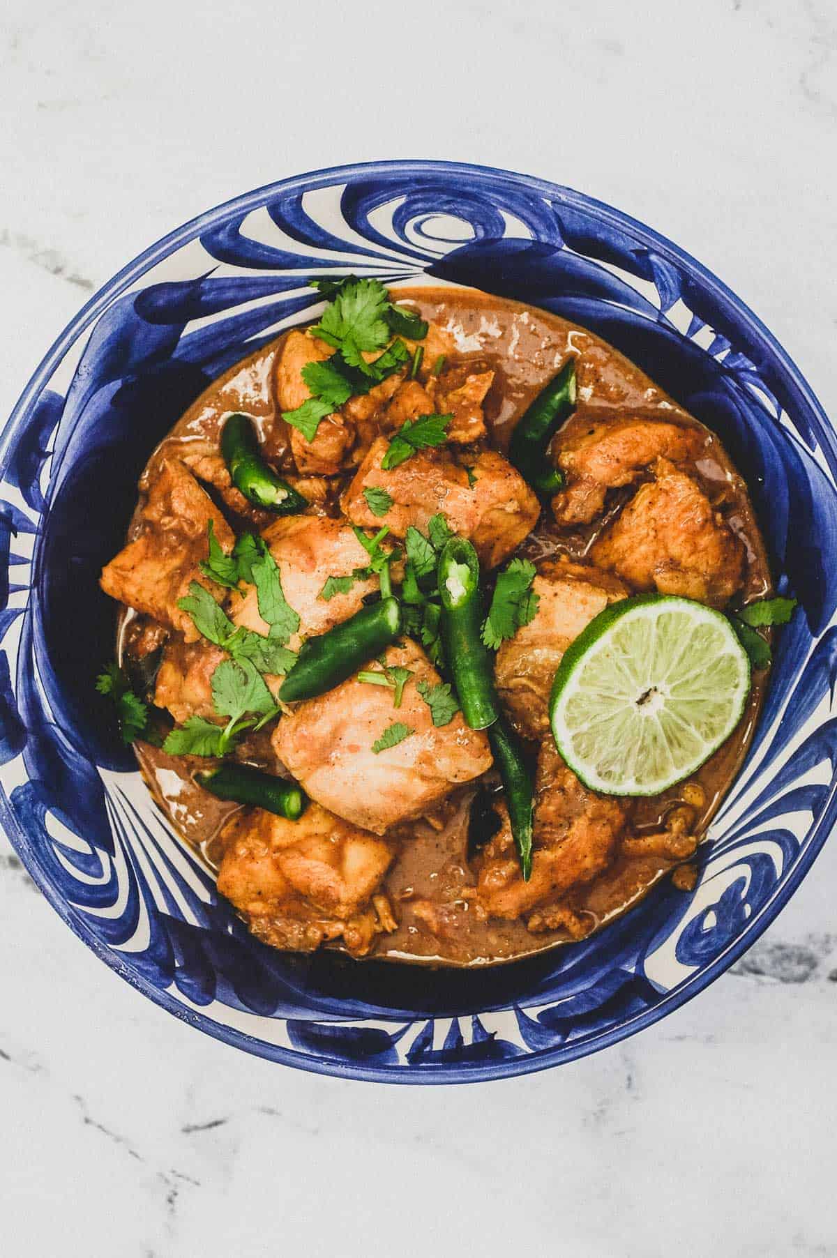 A blue bowl containing Keralan Chicken Curry (Nadan Khozi)