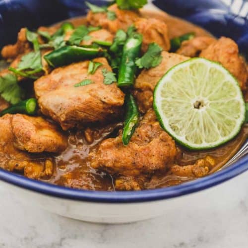 A blue bowl containing Keralan Chicken Curry (Nadan Khozi)