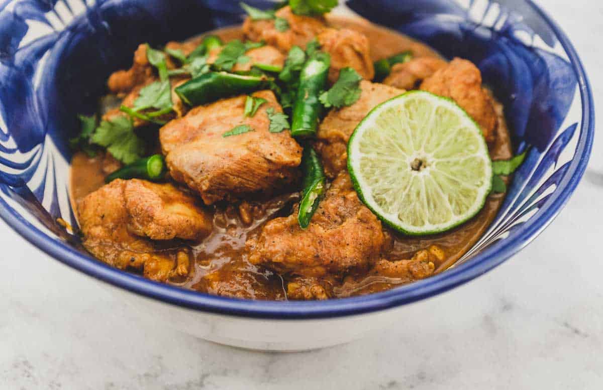 A blue bowl containing Keralan Chicken Curry (Nadan Khozi)