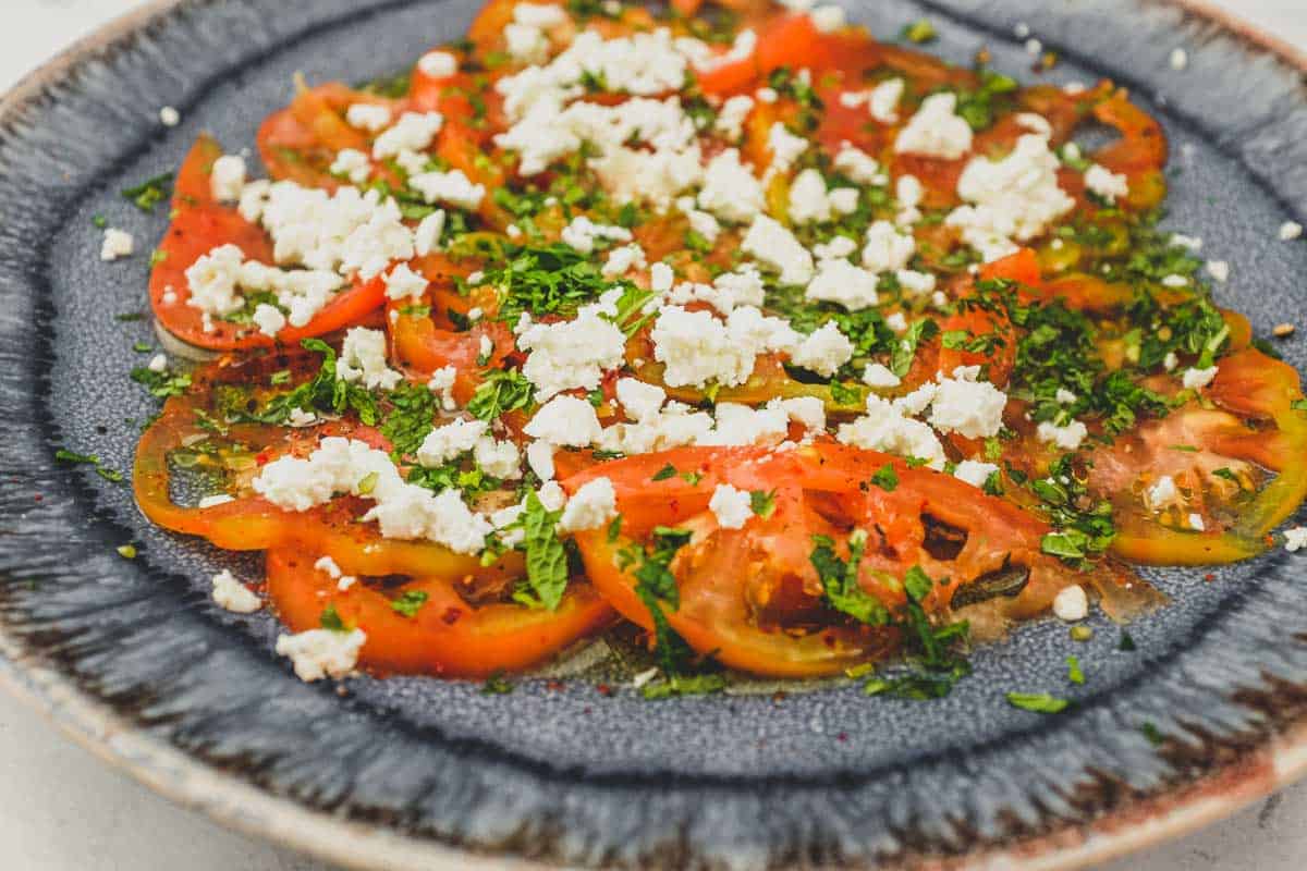 Tomatoes dressed in vinegar and oil with feta cheese and chopped mint