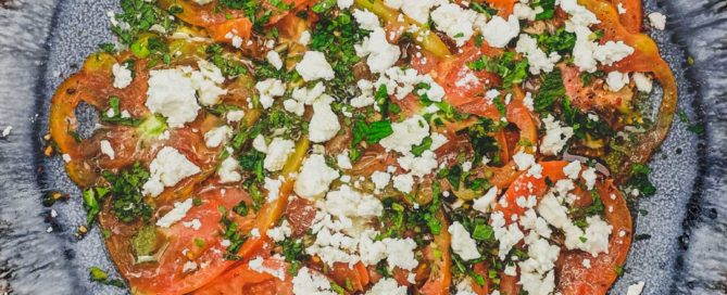 Tomatoes dressed in vinegar and oil with feta cheese and chopped mint
