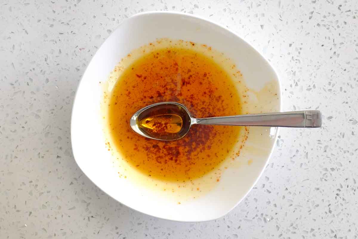 A small bowl of melted butter with Aleppo pepper