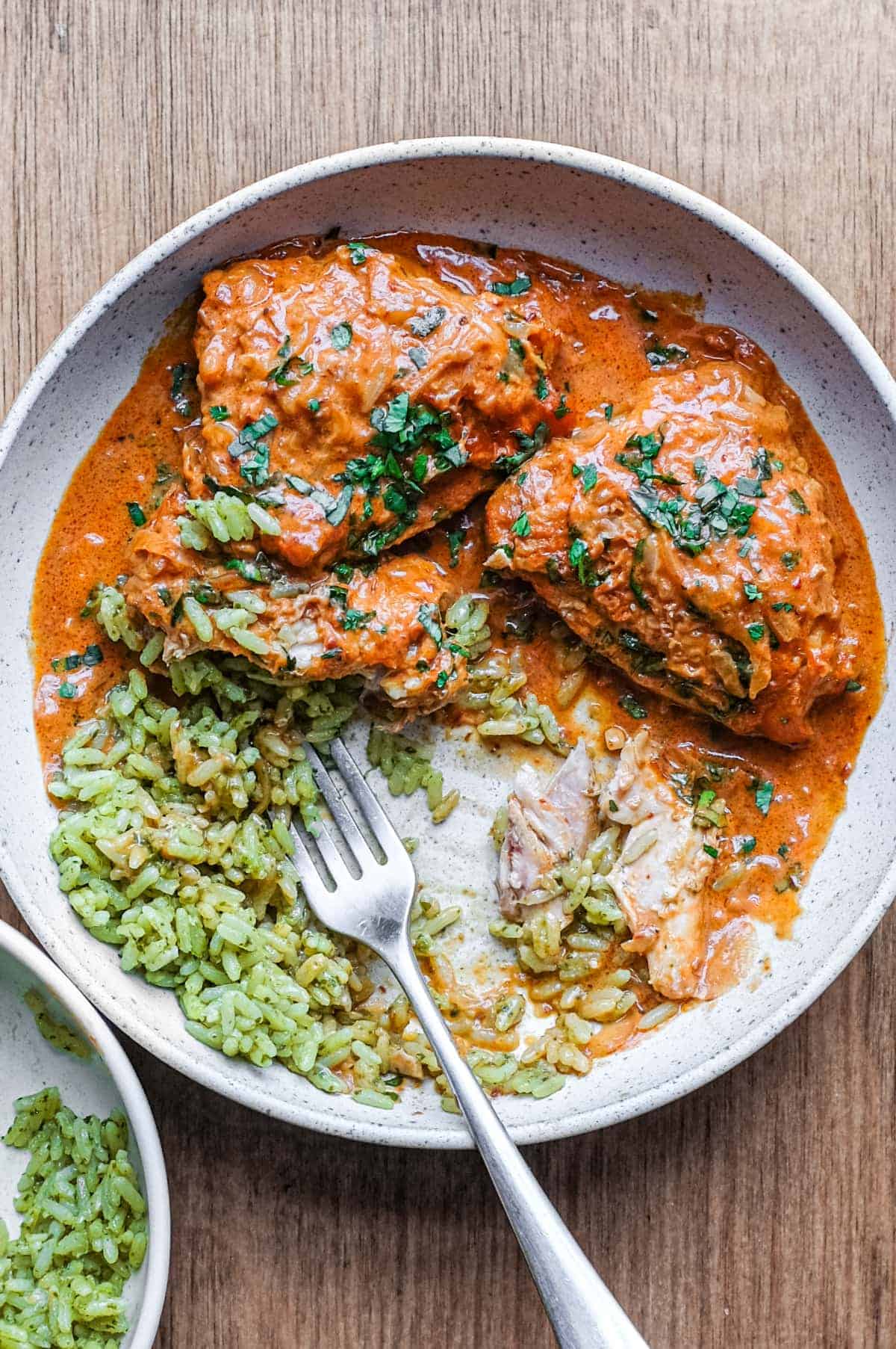 A bowl of Mexican chipotle chicken and green rice with a fork