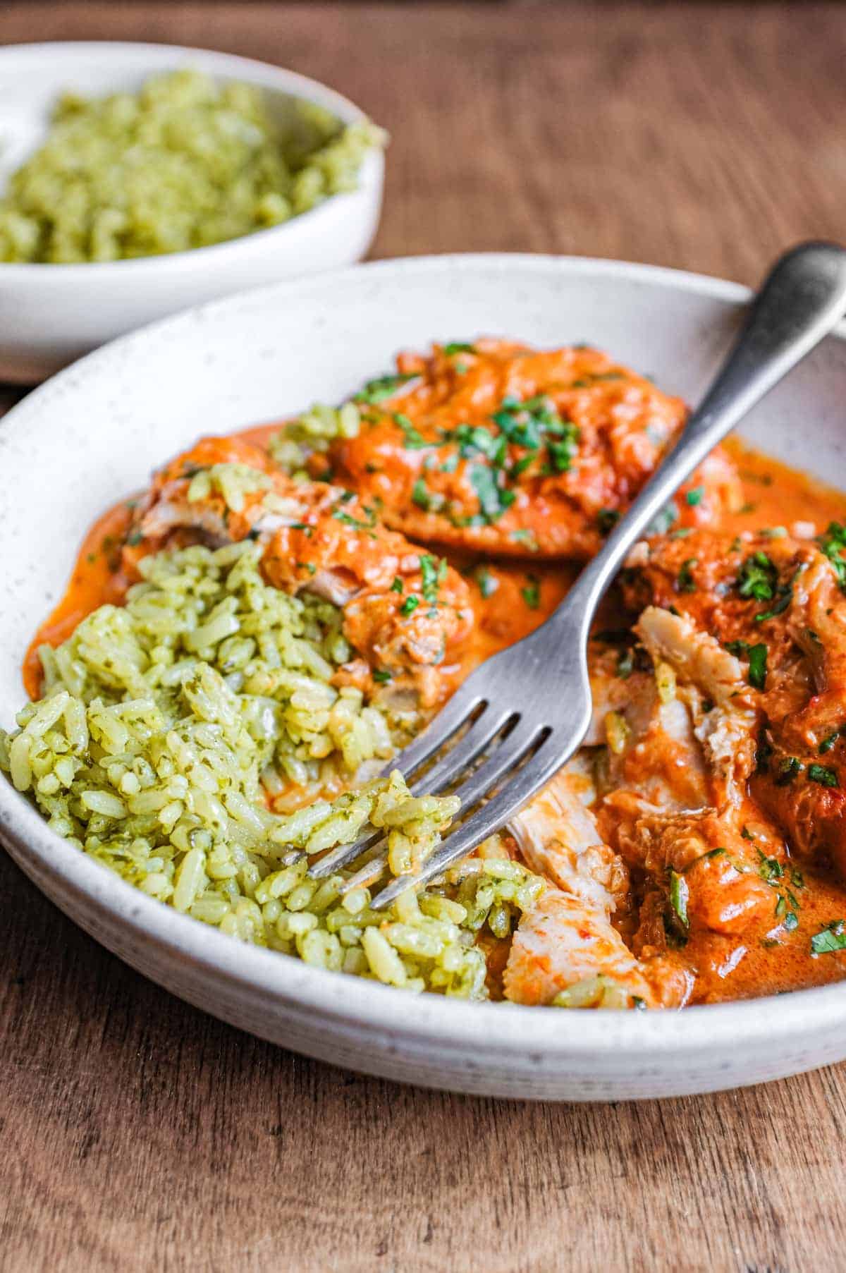 A bowl of Mexican chipotle chicken and green rice with a fork