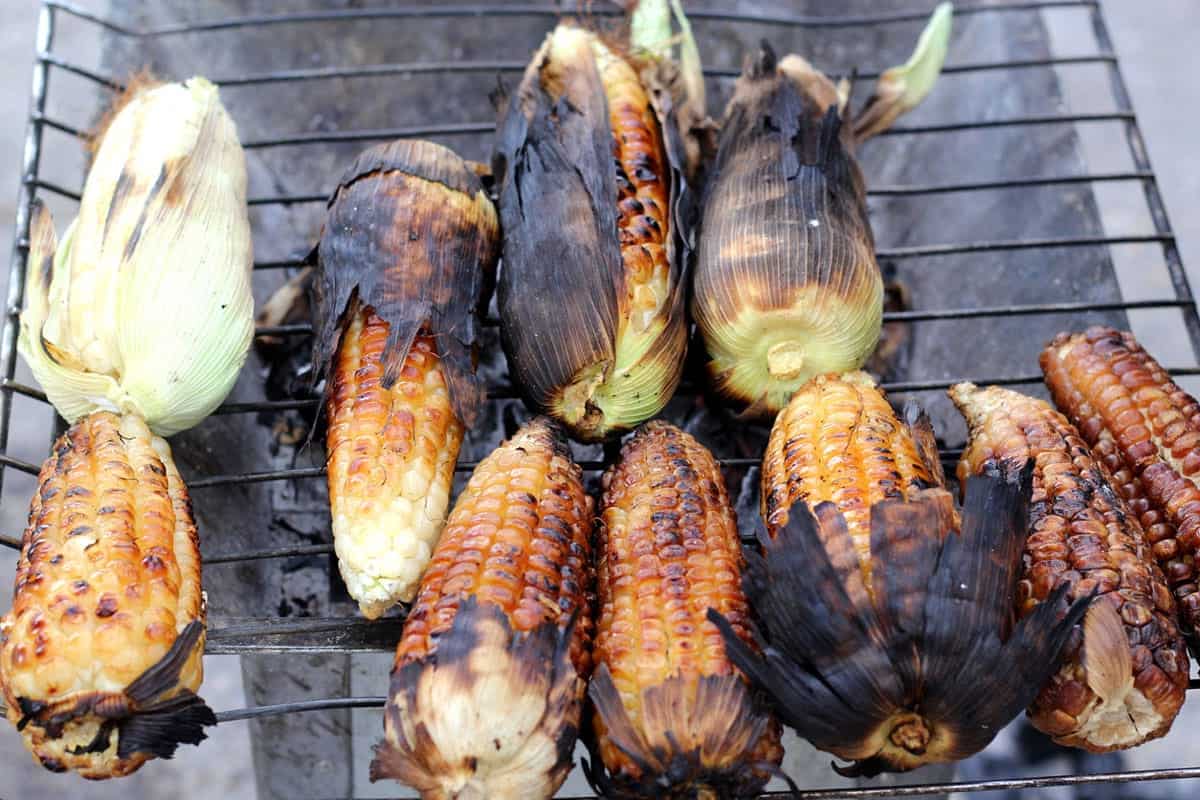 Corn cooking over charcoal to be used for Mexican esquites (street corn)