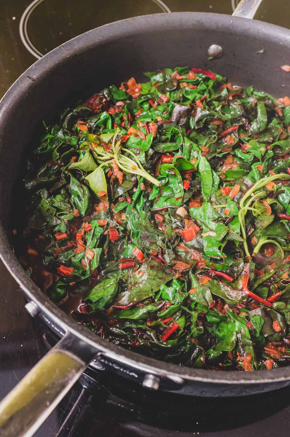 onion, chard stalks and leaves fry in a pan with sage