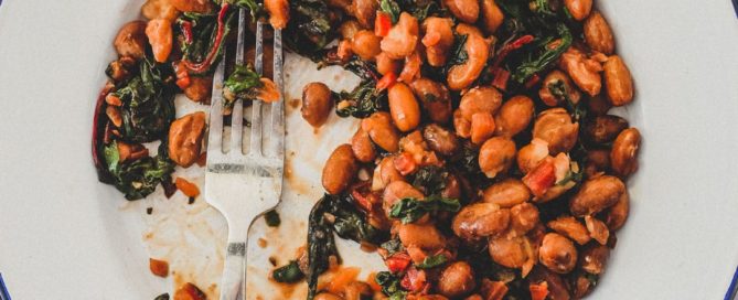 Borlotti beans cooked with chard (silverbeet) on a plate with a fork