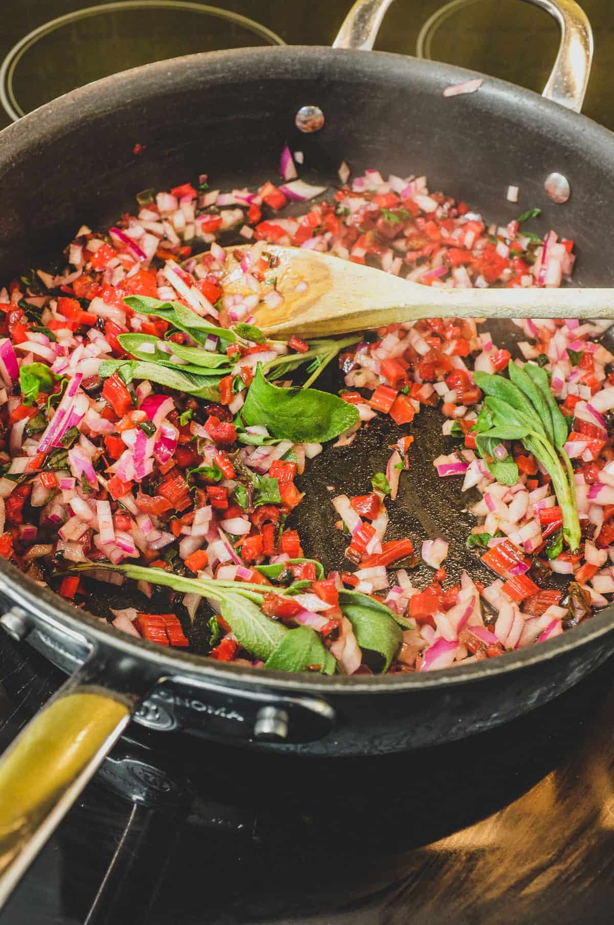 Onion, sage and chard stalks fry in a pan