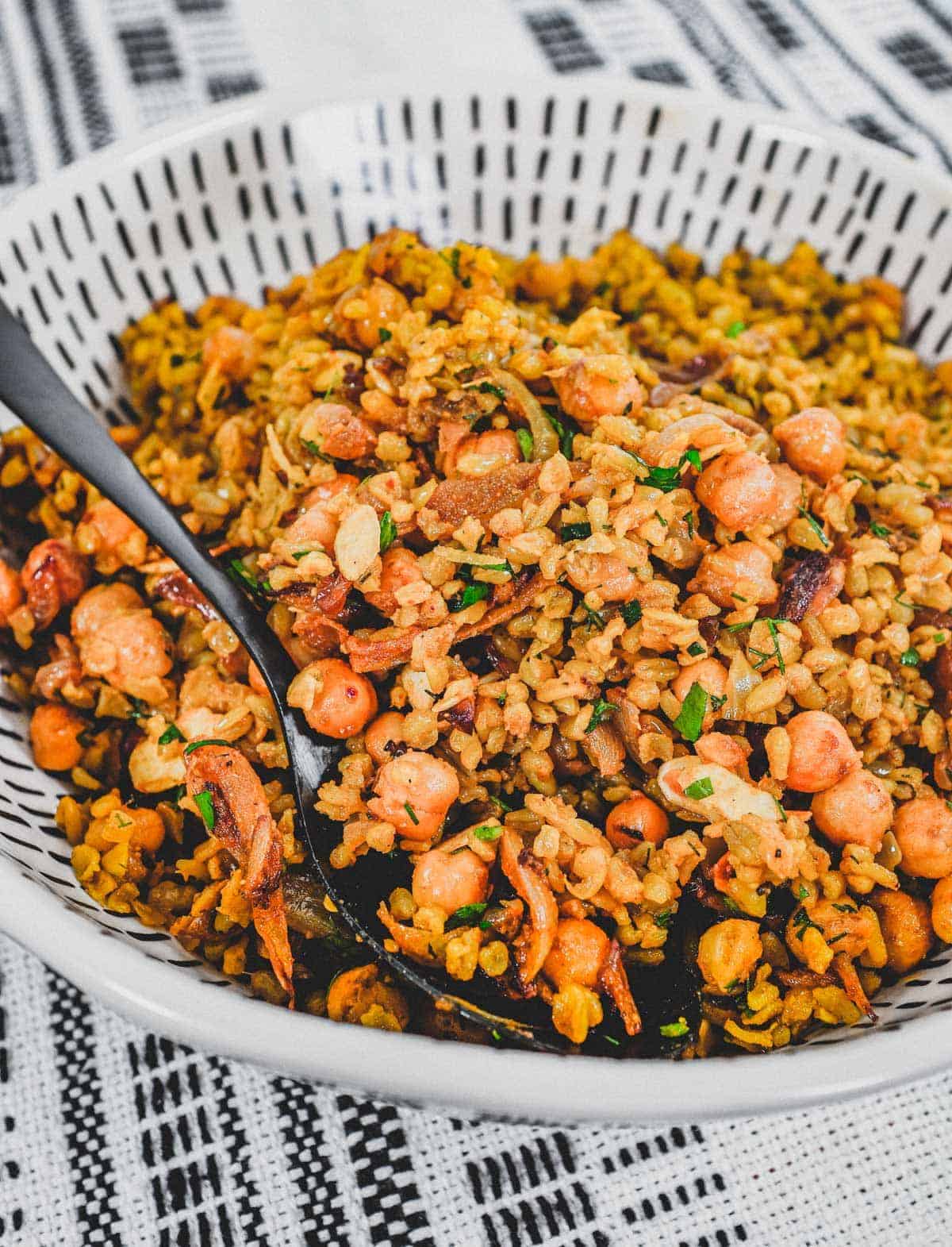 Freekeh cooked with onion and chickpeas in a large serving bowl