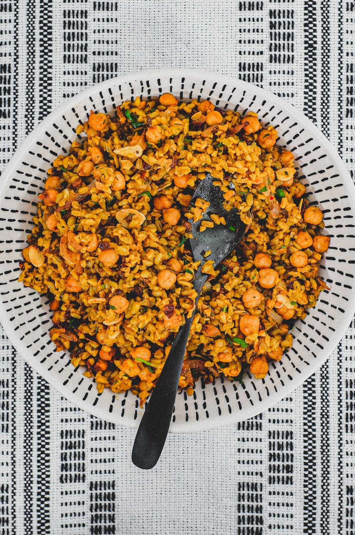 Freekeh cooked with onion and chickpeas in a large serving bowl