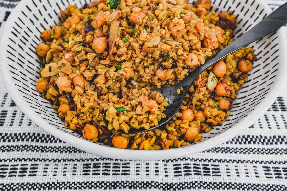 Freekeh cooked with onion and chickpeas in a large serving bowl