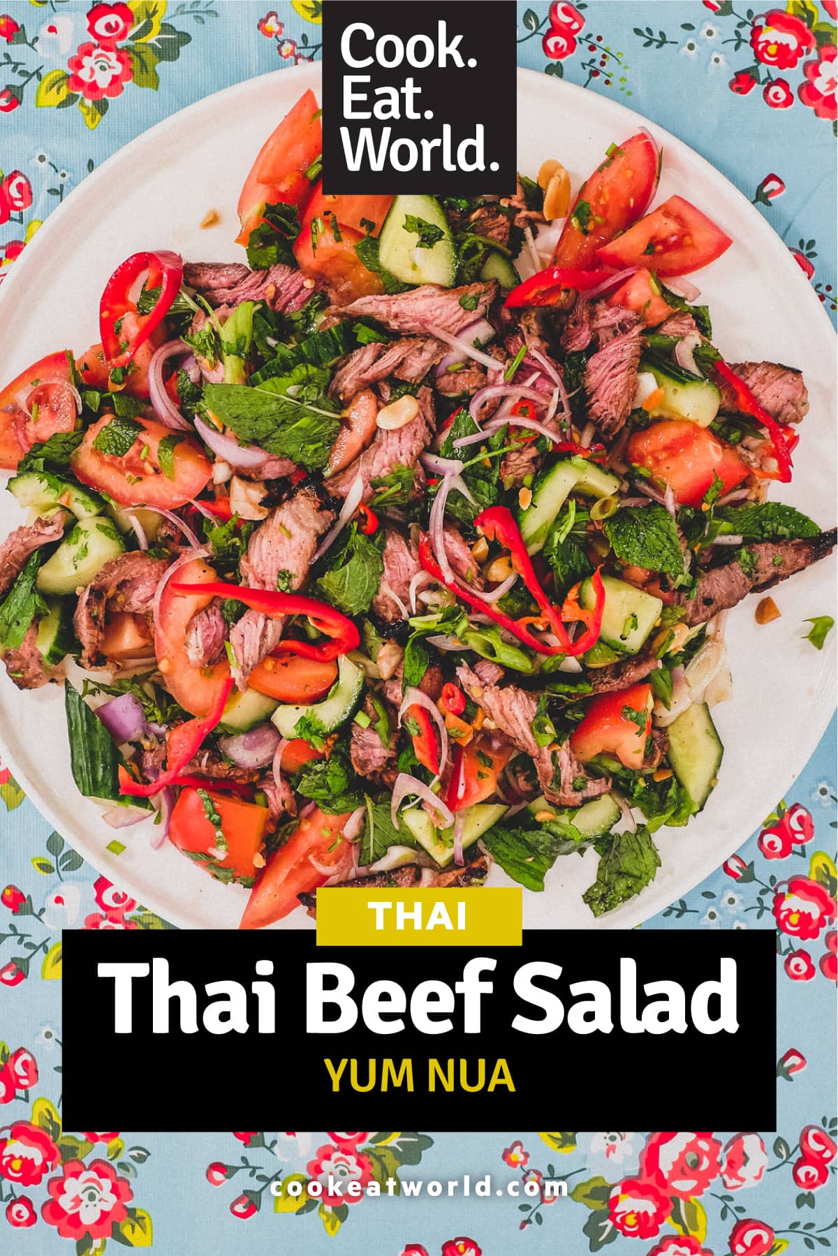 Thinly sliced ribeye steak is served in a salad of mint, cilantro shallots and spring onion in a spicy chilli dressing. Roasted peanuts are scattered over the salad. It sits non a bright blue floral plastic tablecloth like the ones in Thai markets.