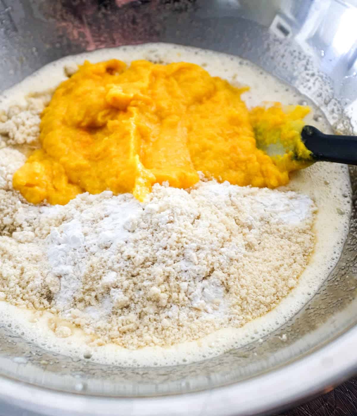 Pureed orange with cake mixture in a bowl, ready to be combined.