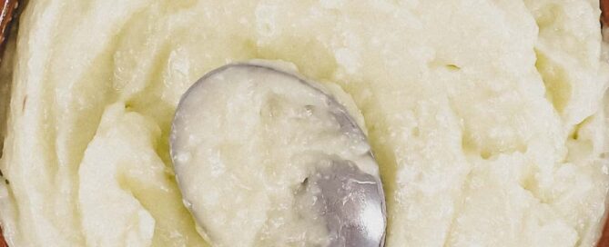 A small bowl of Lebanese garlic sauce, Toum with a spoon