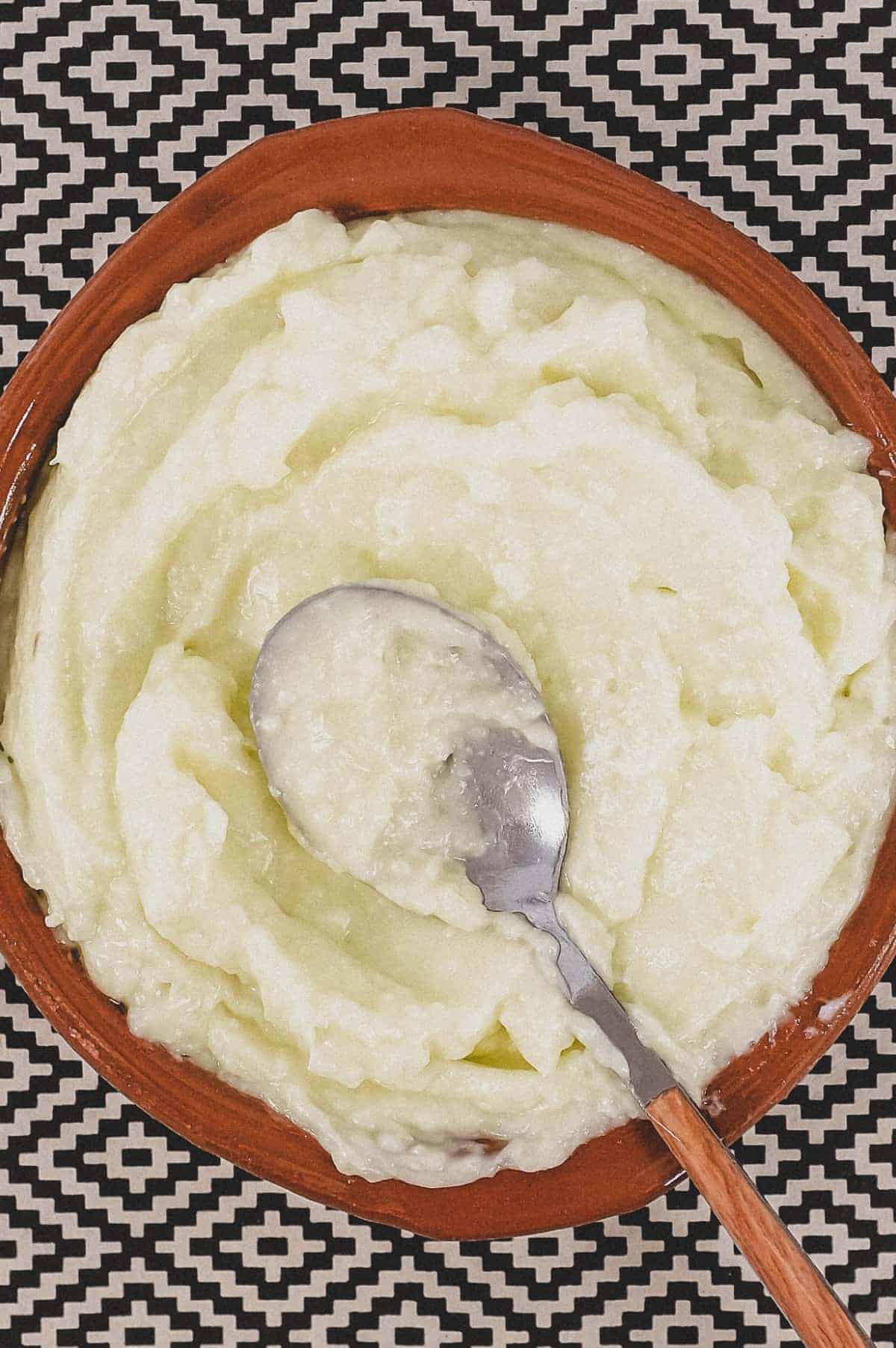 A small bowl of Lebanese garlic sauce, Toum with a spoon