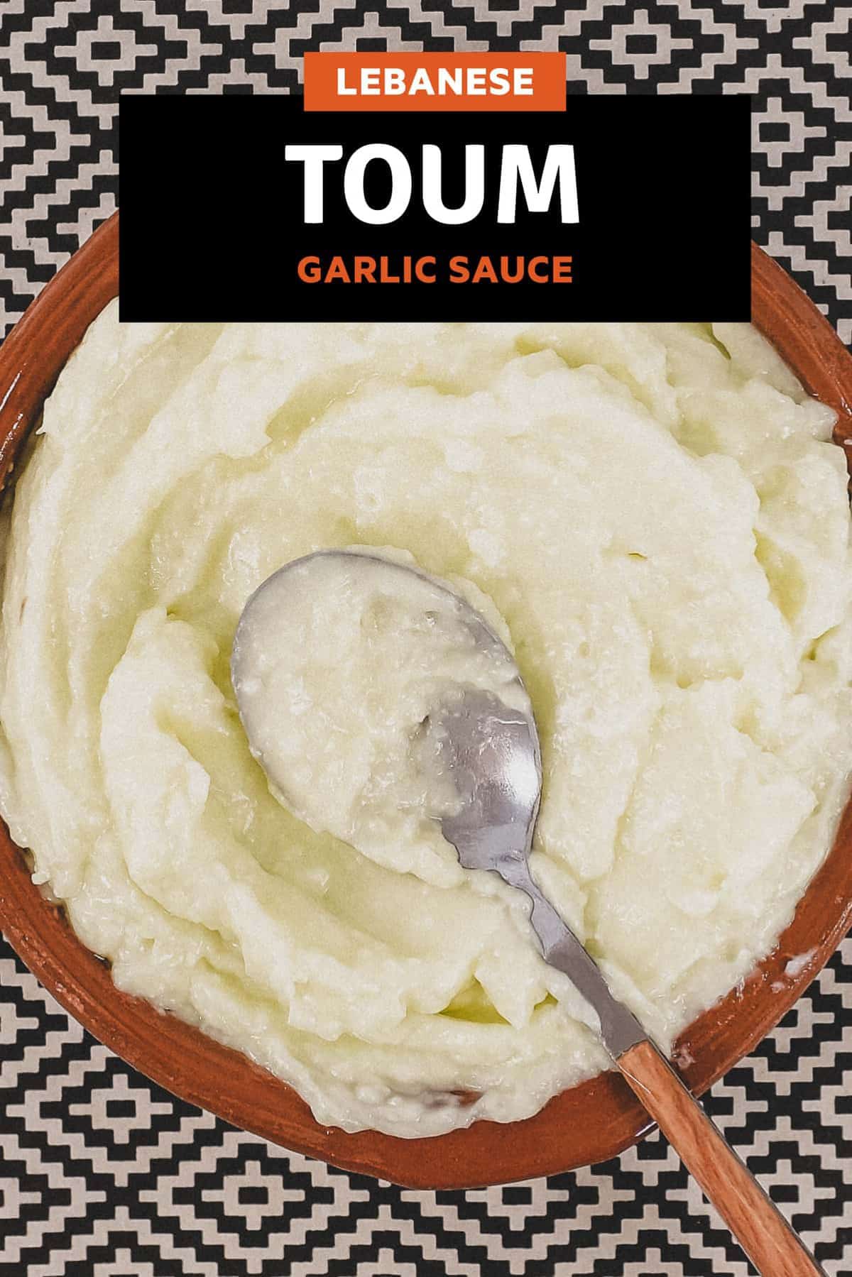 A small bowl of Lebanese garlic sauce, Toum with a spoon