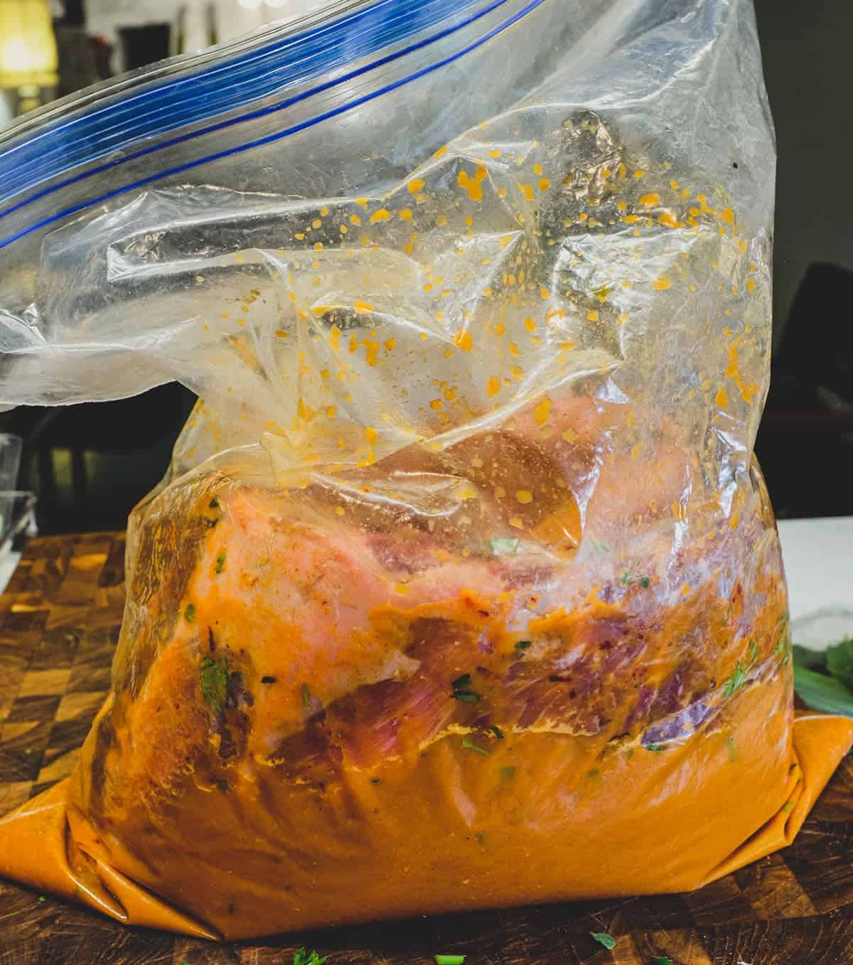 2 pork rib racks are placed in a plastic bag and a marinade of sherry, onion, garlic and paprika are poured over to rest for 24 hours in the fridge.