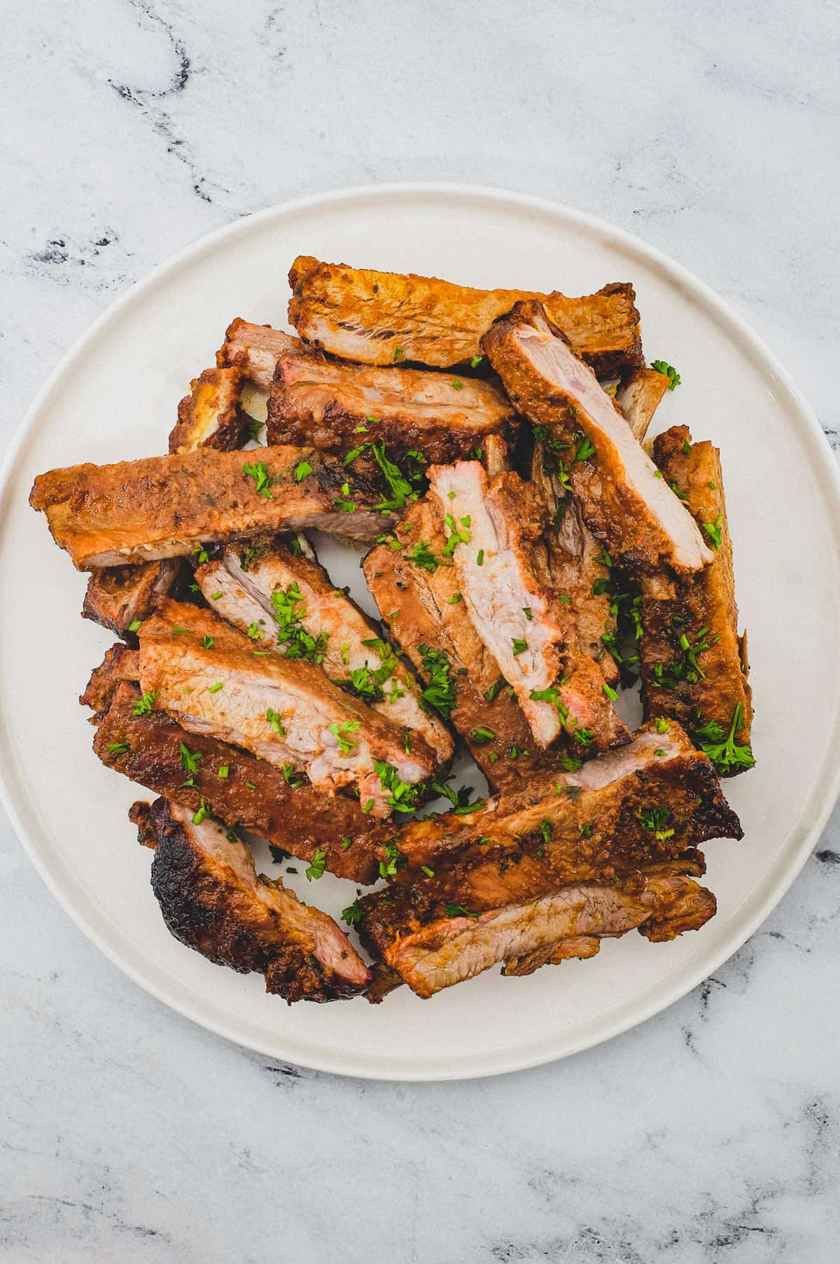 Pork ribs sit on a large platter.