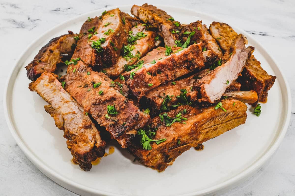 Pork ribs sit on a large platter.