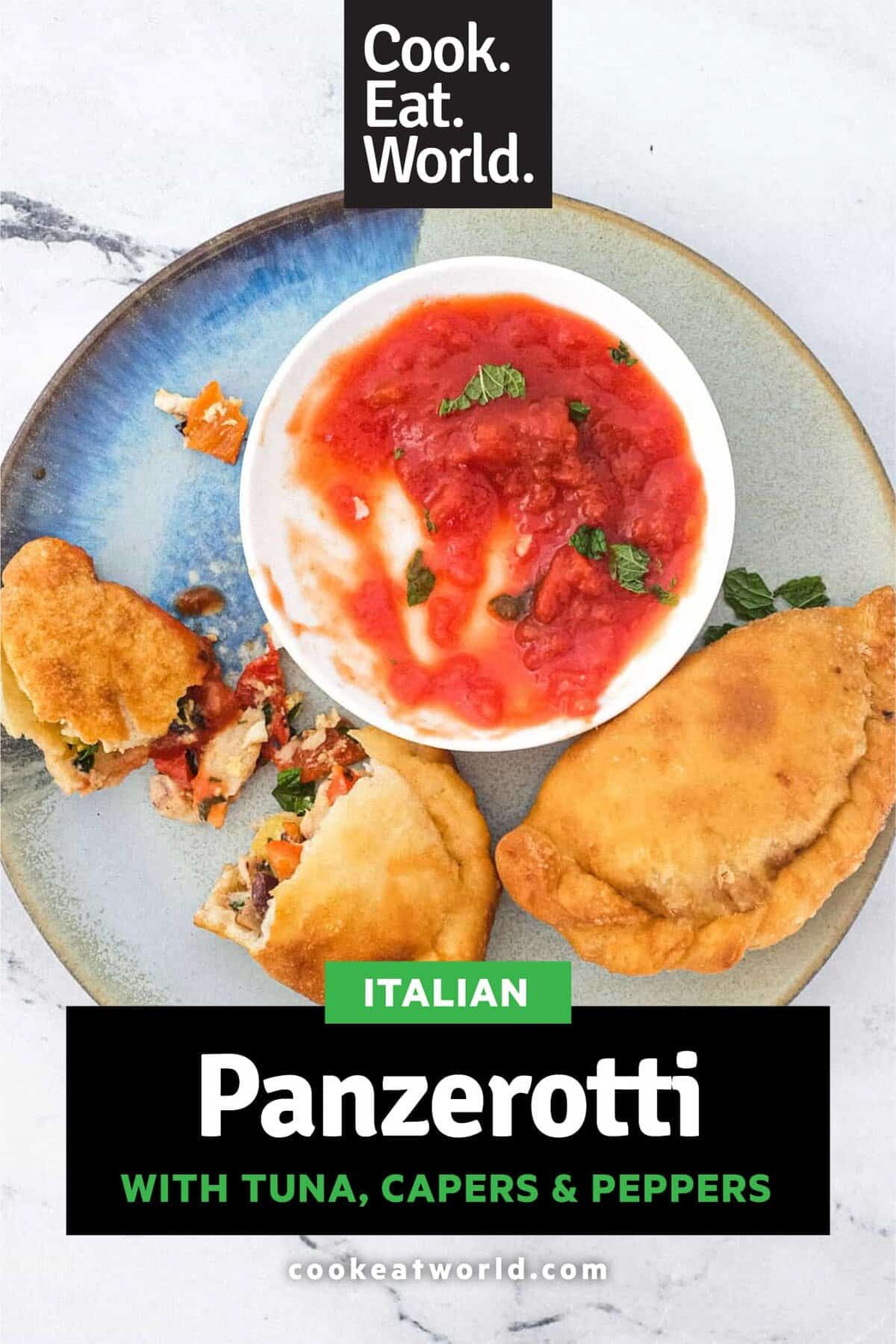 Panzerotti sits on a plate with the filling on show of olives, tuna, egg and red pepper alongside a small dish of tomato sauce