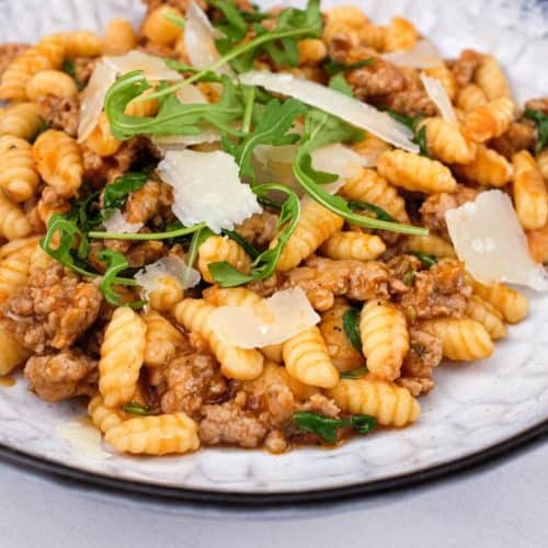 A plate of Malloreddus (Gnocchetti Sardi) with Sausage Ragù with arugula and Pecorino Sardi Cheese
