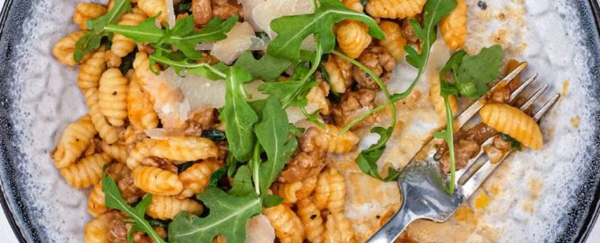 A plate of Malloreddus (Gnocchetti Sardi) with Sausage Ragù with arugula and Pecorino Sardi Cheese