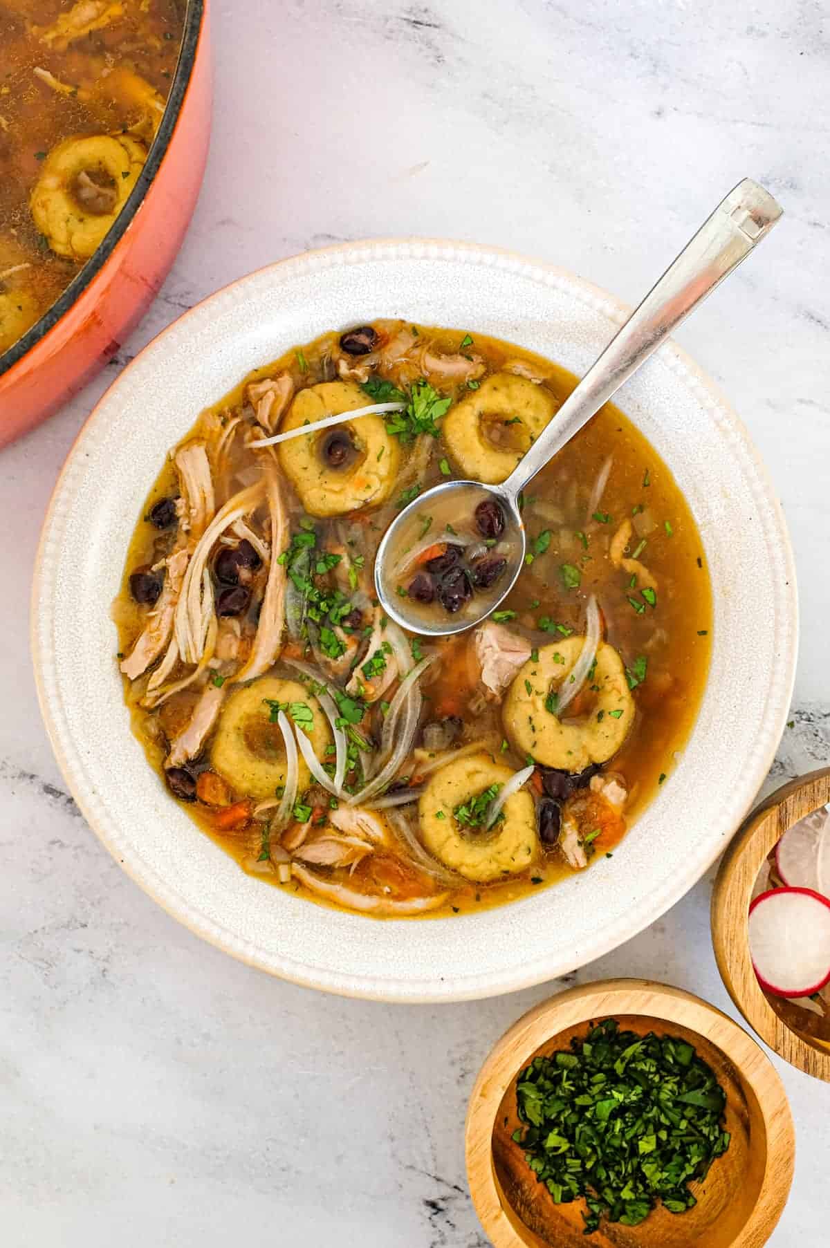 A bowl of chicken soup with Mexican dumplings called chochoyotes.