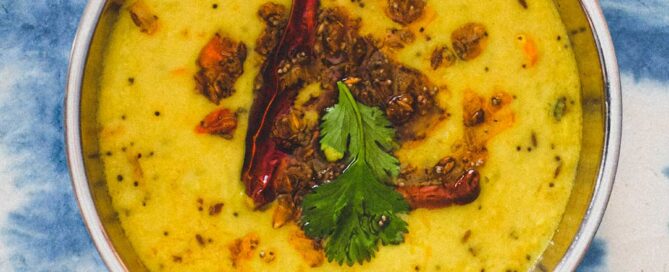 A bowl of parippu dal on a blue background