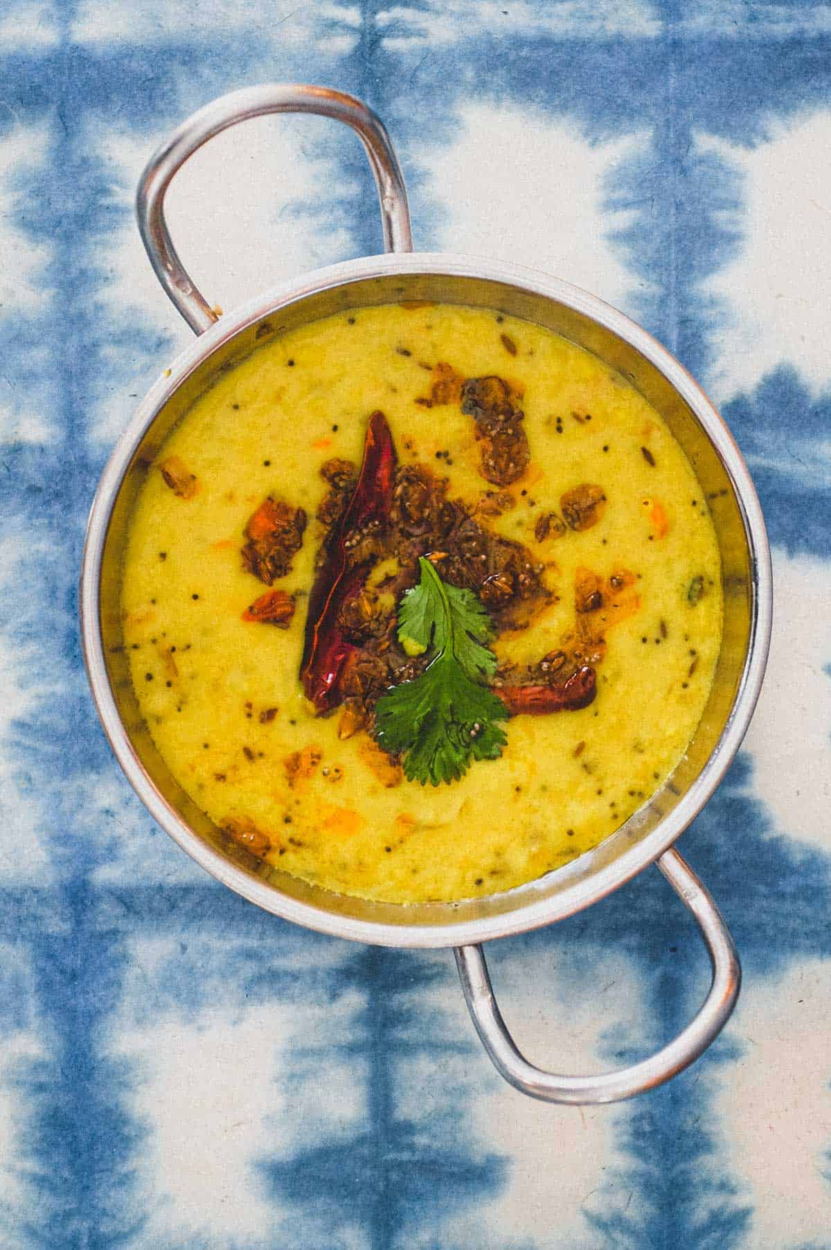 A bowl of parippu dal on a blue background