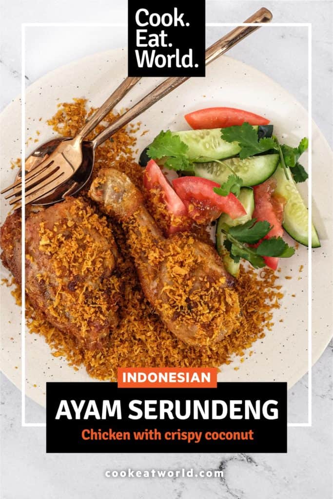 A platter of Ayam Serundeng fried chicken with crispy coconut with a side salad of cucumber and tomato