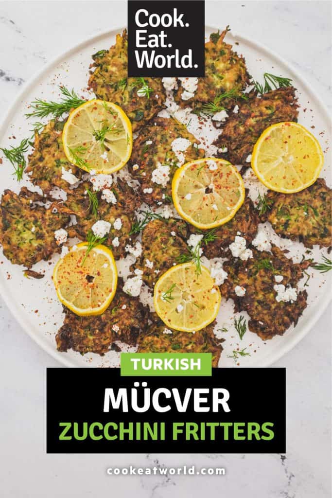 A platter of zucchini fritters with feta cheese and lemon slices