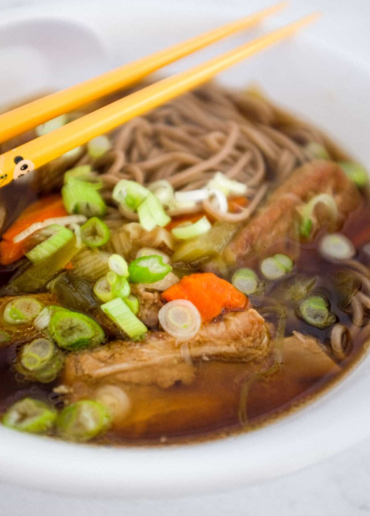 A bowl of pork rib soup with soba noodles