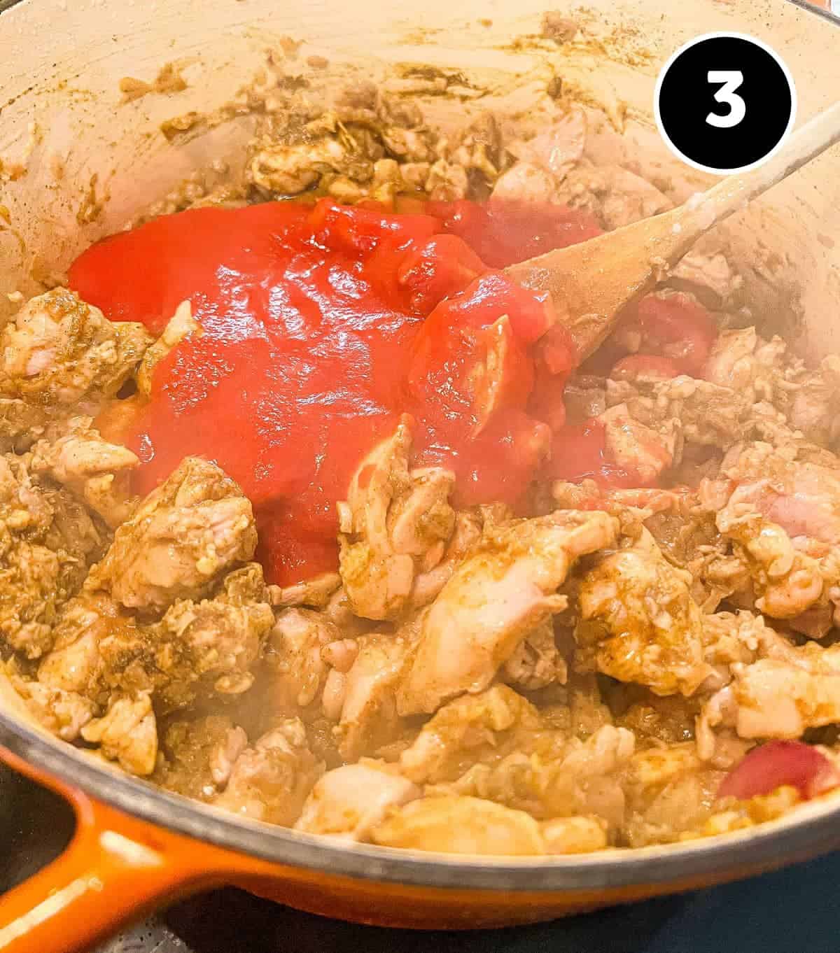 Adding the spice powder to the chicken alongside tomato for Chicken Pathia Curry