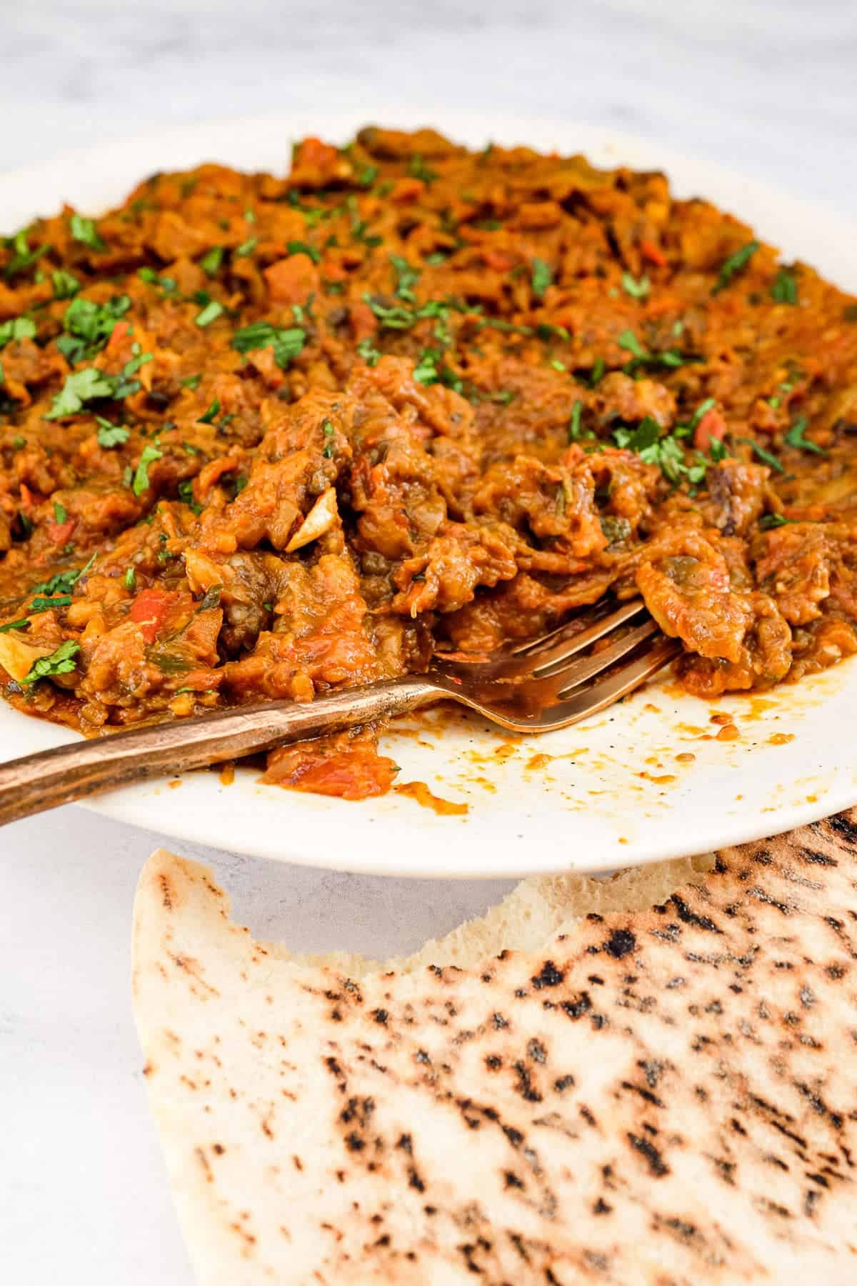 Moroccan Zaalouk on a platter with bread and a copper spoon