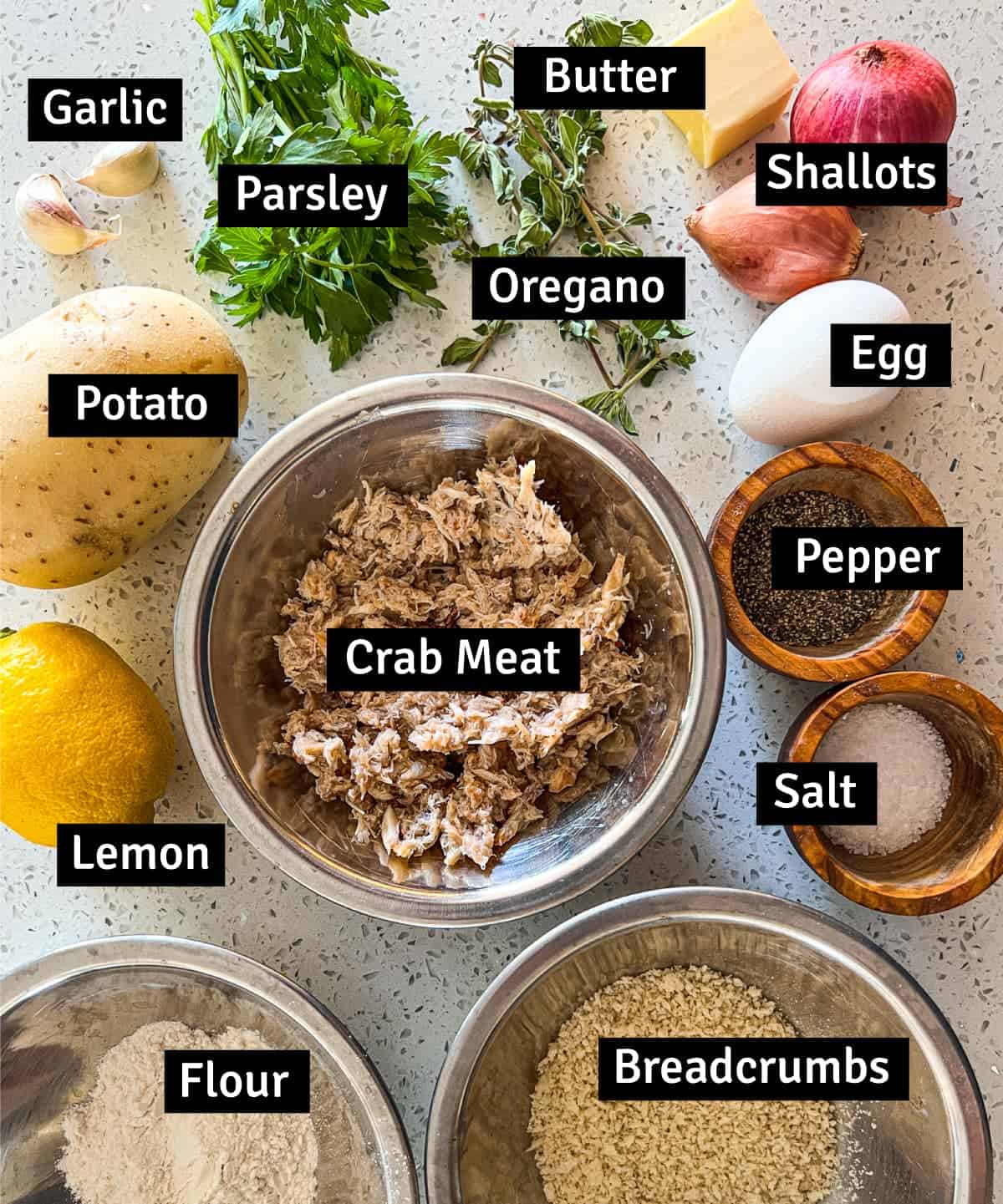 The ingredients for crab croquettes including crab meat, potato, lemon, herbs and more.