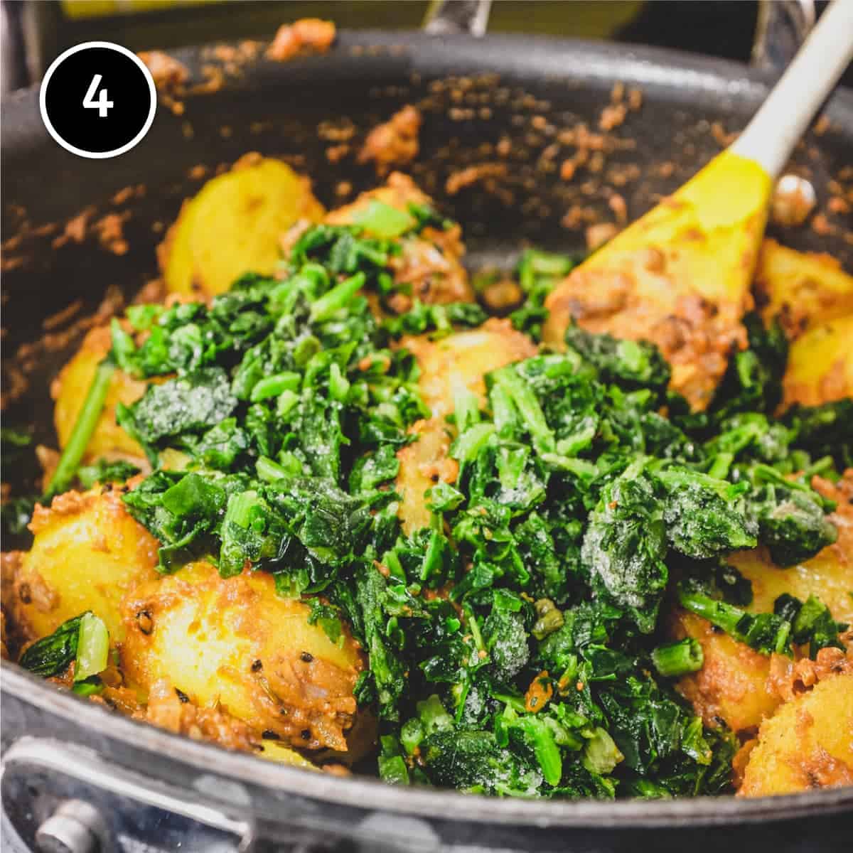 Adding frozen spinach to the pan for Saag Aloo (Spinach & Potato curry)