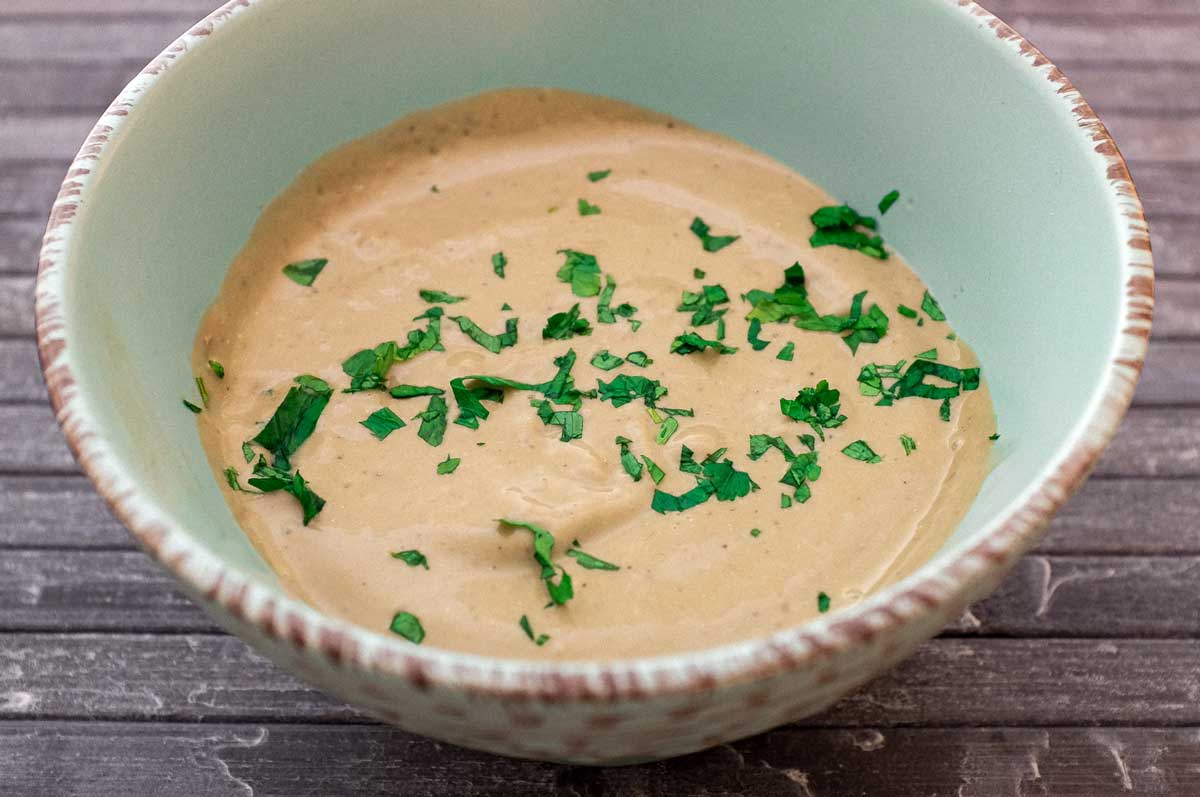 A bowl of Anchovy Sauce, scattered with fresh parsley.