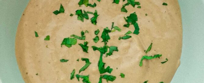 A bowl of Anchovy sauce scattered with fresh parsley.