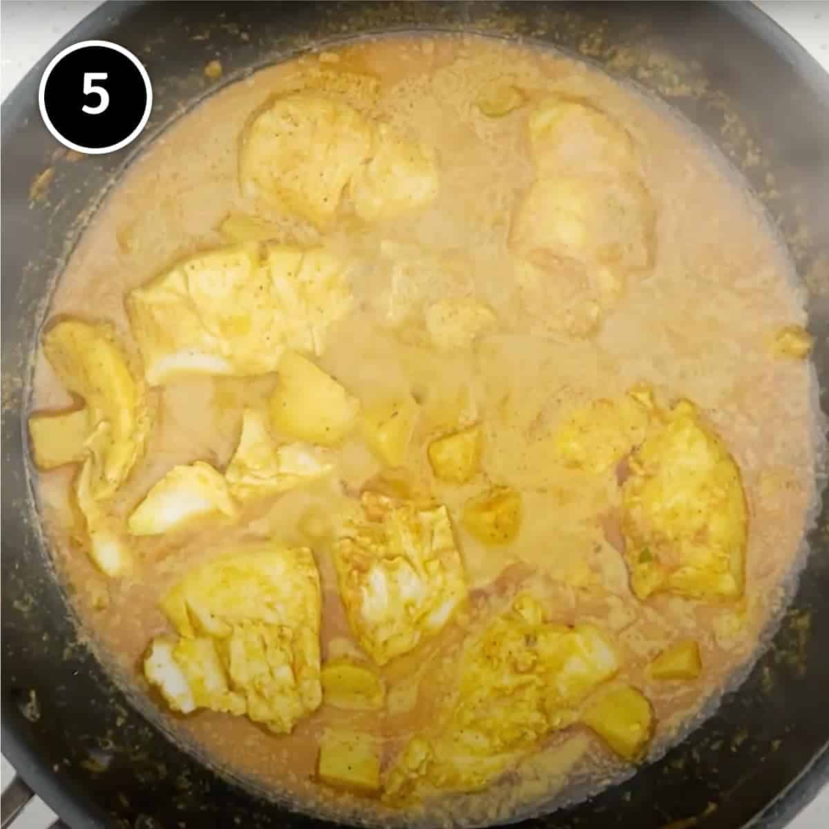 A fish curry simmering in a pan