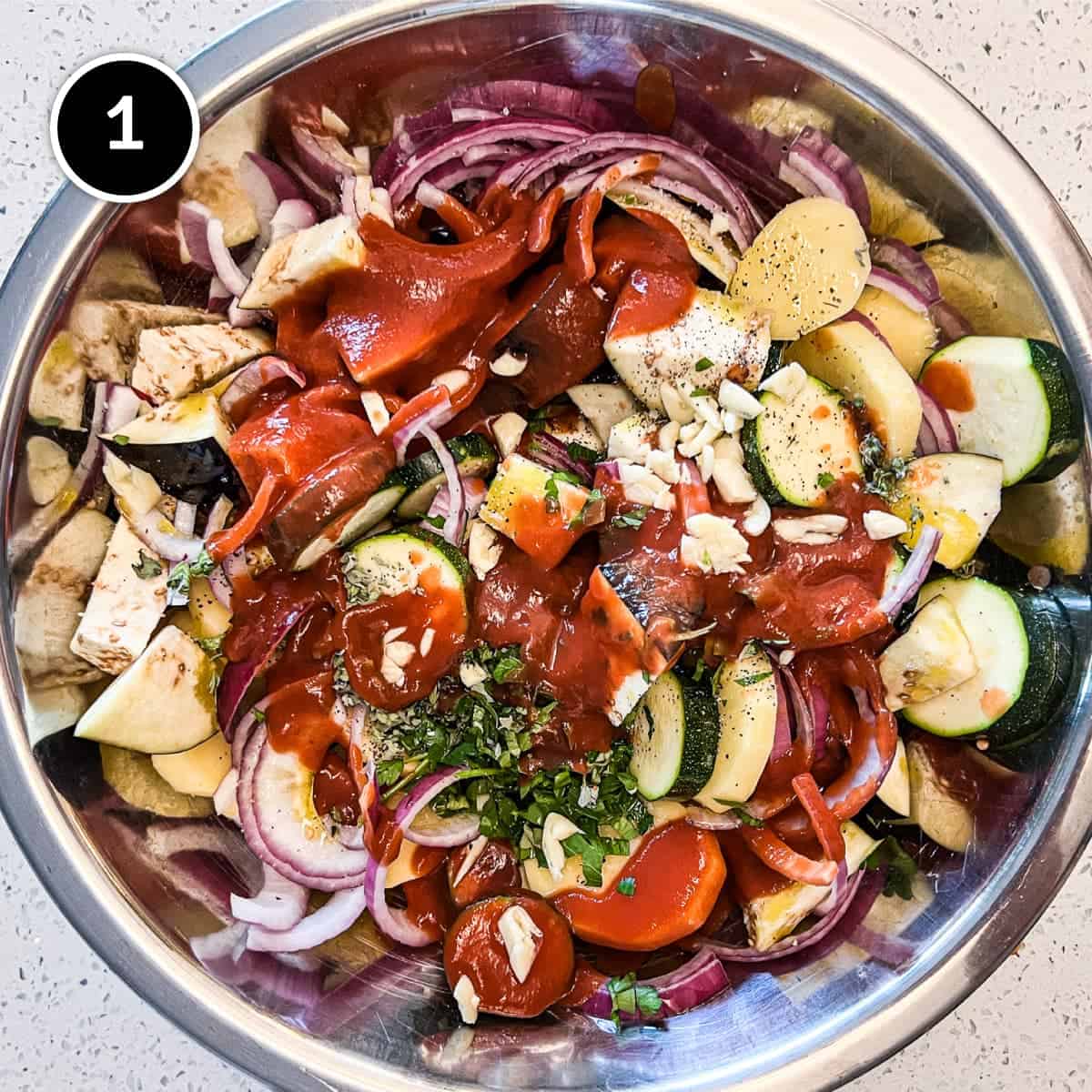 The ingredients for Briam (Greek Roasted Vegetables) in a large bowl.