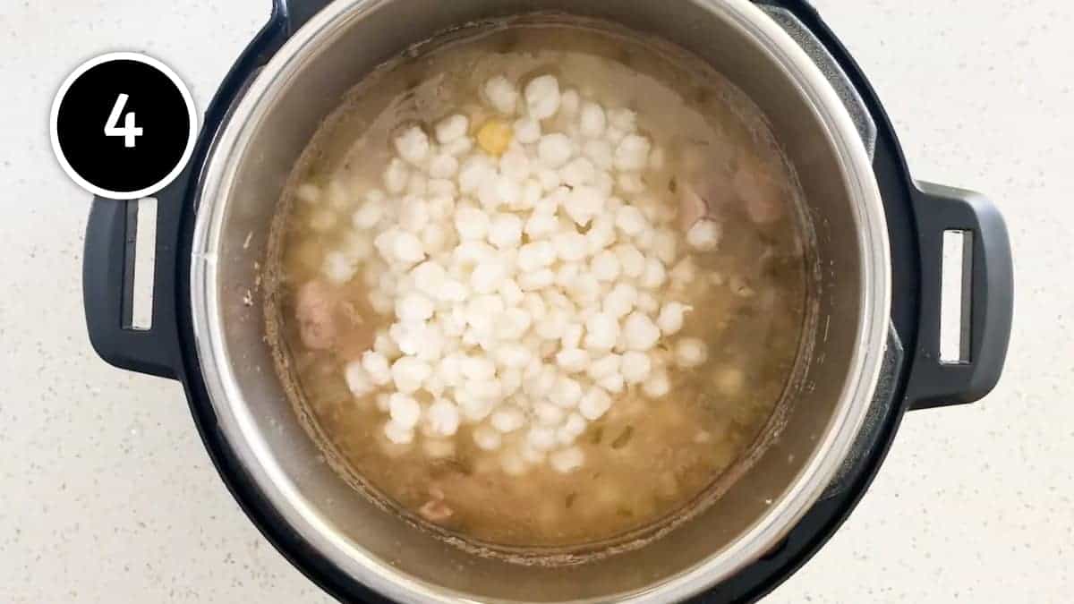 Adding hominy corn to the Mexican Pozole Blanco soup