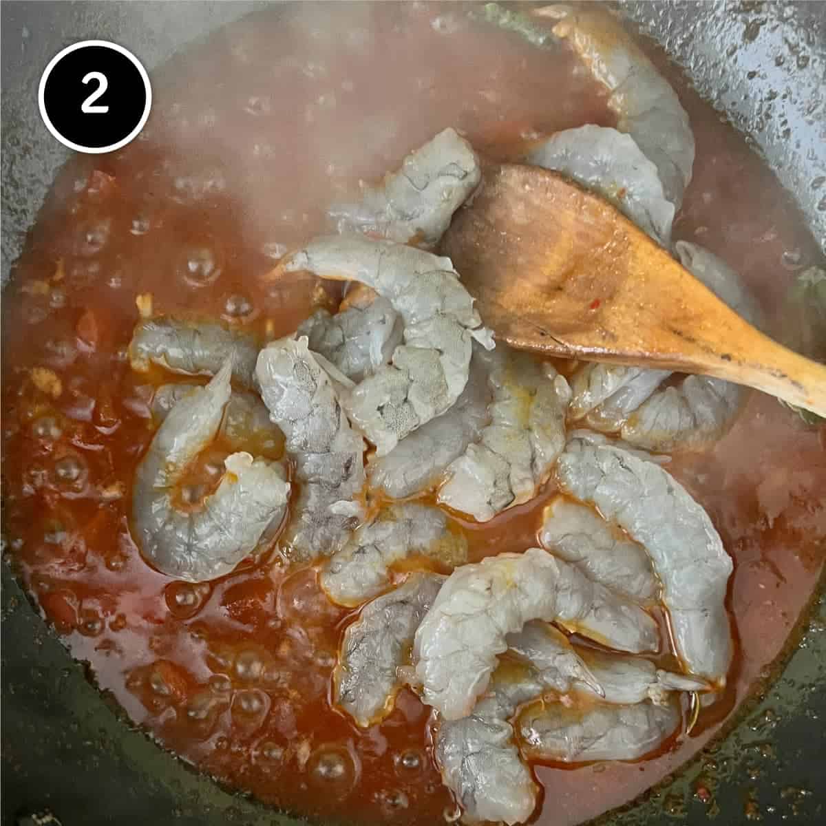 Adding prawns to the sambal sauce for Sambal Udang (Sambal Prawns)